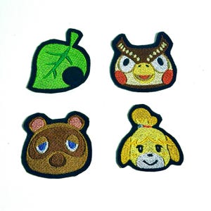 May include: Four embroidered patches featuring characters from the Animal Crossing video game. The patches include a green leaf, an owl, a bear, and a dog, each with detailed stitching and a black border. These patches are suitable for clothing or accessories.