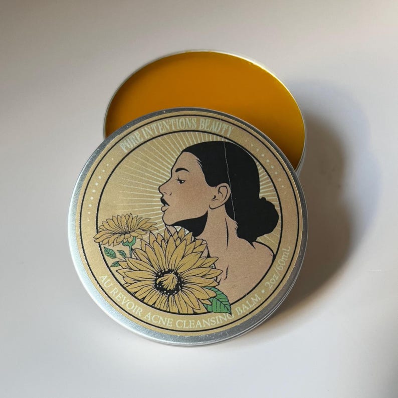 Pu&ograve; includere: Un barattolo rotondo d'argento di balsamo detergente per l'acne con interno dorato. Il coperchio presenta il profilo di una donna, girasoli e il testo "PURE INTENTIONS BEAUTY" e "AU REVOIR ACNE CLEANSING BALM". Il balsamo &egrave; di 60 ml.