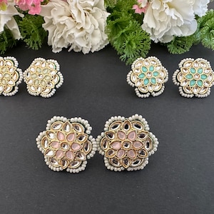 May include: A set of six floral-shaped earrings with pearl accents. The earrings feature a variety of colors, including pink, green, and white.