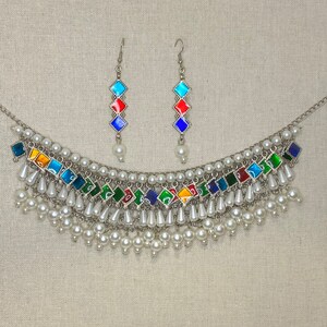 Peut inclure: Un collier en argent avec un motif de carreaux de verre multicolores et des accents de perles. Le collier est assorti &agrave; des boucles d'oreilles.