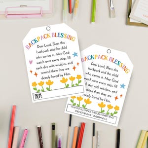 May include: Two white rectangular paper tags with rounded top corners and a hole for hanging. The text reads BACKPACK BLESSING followed by a prayer, yellow flower illustrations, and a space for a name. One tag includes the verse Philippians 4:13.