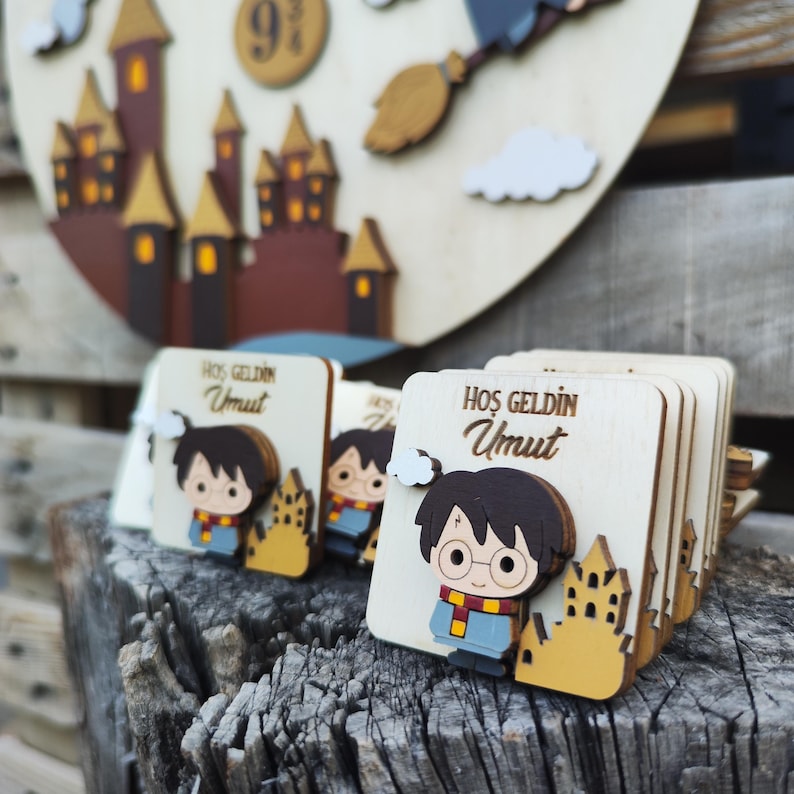 May include: Wooden Harry Potter themed party favors with a cartoon image of Harry Potter and the text "HOS GELDIN Umut" on each favor.