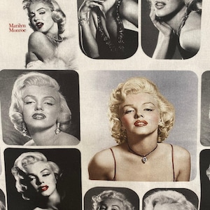 May include: A fabric featuring multiple images of Marilyn Monroe in various poses. The images are in both black and white and color, showcasing her iconic blonde hair and red lipstick. The text "Marilyn Monroe" is printed in red.