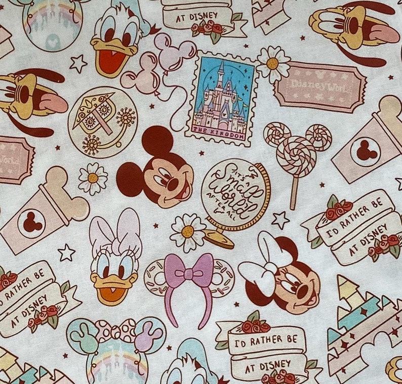 May include: A white fabric with a repeating pattern of Disney characters and icons. The characters include Mickey Mouse, Minnie Mouse, Donald Duck, Goofy, and a castle. The icons include a lollipop, a globe, a flower, and a star. The fabric is printed with the text "It's a Small World After All" and "I'd Rather Be At Disney".