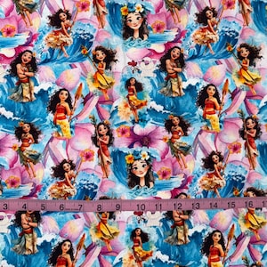 K&ouml;nnte beinhalten: Ein Stoffdruck mit einem sich wiederholenden Muster aus Moana-Figuren, blauen Meereswellen und rosa Hibiskusbl&uuml;ten. Ein Ma&szlig;band liegt quer &uuml;ber der Mitte und zeigt eine L&auml;nge von 53 cm auf dem farbenfrohen, illustrierten Textildesign.
