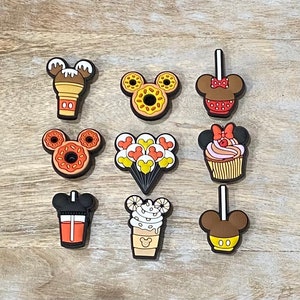 May include: Nine colorful Mickey Mouse-shaped charms featuring various Disney-themed treats, including a Mickey Mouse ice cream cone, a Mickey Mouse donut, a Mickey Mouse cupcake, a Mickey Mouse apple, a Mickey Mouse balloon, a Mickey Mouse coffee cup, and a Mickey Mouse pretzel.