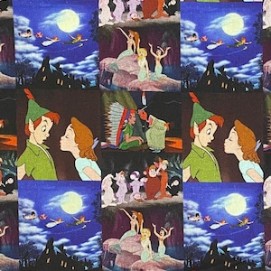 May include: Fabric featuring a repeating pattern of scenes from the animated film Peter Pan. The design includes images of Peter Pan, Wendy, mermaids, and other characters, set against a dark blue night sky with a full moon and Neverland silhouettes.