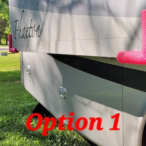 May include: A section of a silver and white recreational vehicle with the name "Phaeton" in black script. Bright pink foam corner protectors are attached to the vehicle. The text "Option 1" is in red.