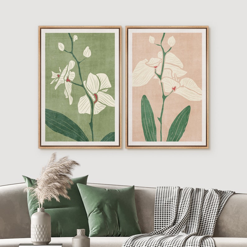 Pu&ograve; includere: Due stampe incorniciate di orchidee bianche con foglie verdi su uno sfondo verde chiaro e rosa chiaro.