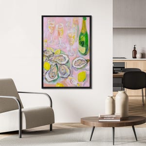 May include: An abstract painting of a still life featuring oysters, lemons, champagne glasses, and a bottle of champagne. The artwork has a pink background and is framed in black. The oysters are open, and the lemons are yellow.