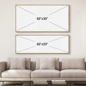 May include: Two framed canvas art pieces, one 60"x30" and the other 60"x20", are displayed on a white wall. The frames are a light brown color. The text "60"x30"" and "60"x20"" are printed on the canvas. A beige sofa is in the foreground.