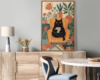 May include: A framed art print depicts a black cat relaxing in an orange armchair, holding a mug. The cat is surrounded by potted plants and a small table with a mug. The artwork has a colorful, textured style, with a wooden frame.