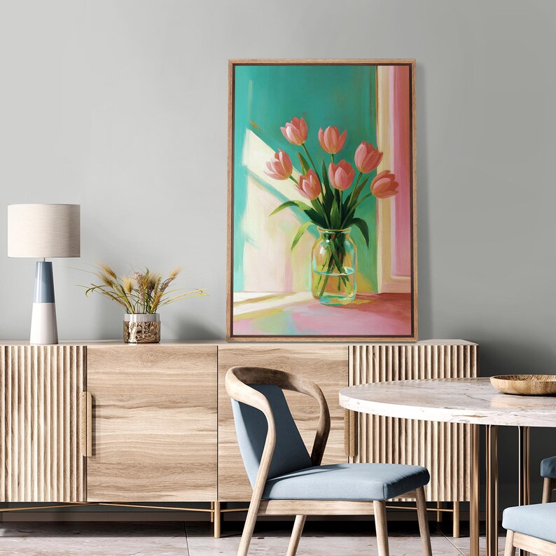 Pu&ograve; includere: Dipinto incorniciato raffigurante un vaso di tulipani rosa davanti a una finestra. Lo sfondo &egrave; un mix di tonalit&agrave; turchese, rosa e giallo. Il dipinto &egrave; esposto sopra un mobile in legno con una lampada e un vaso decorativo.