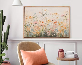 May include: A rectangular framed wall art print featuring a soft-toned painting of a wildflower meadow with delicate pink, yellow, and blue blossoms against a cream background, displayed in a thin wooden frame with a natural finish.