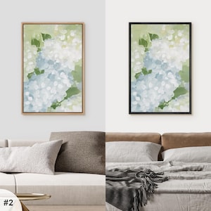 Puede incluir: Dos impresiones art&iacute;sticas florales enmarcadas. Una tiene un marco de madera natural, la otra un marco negro. Ambas presentan una pintura al estilo acuarela de hortensias blancas y azules con hojas verdes sobre un fondo verde claro.