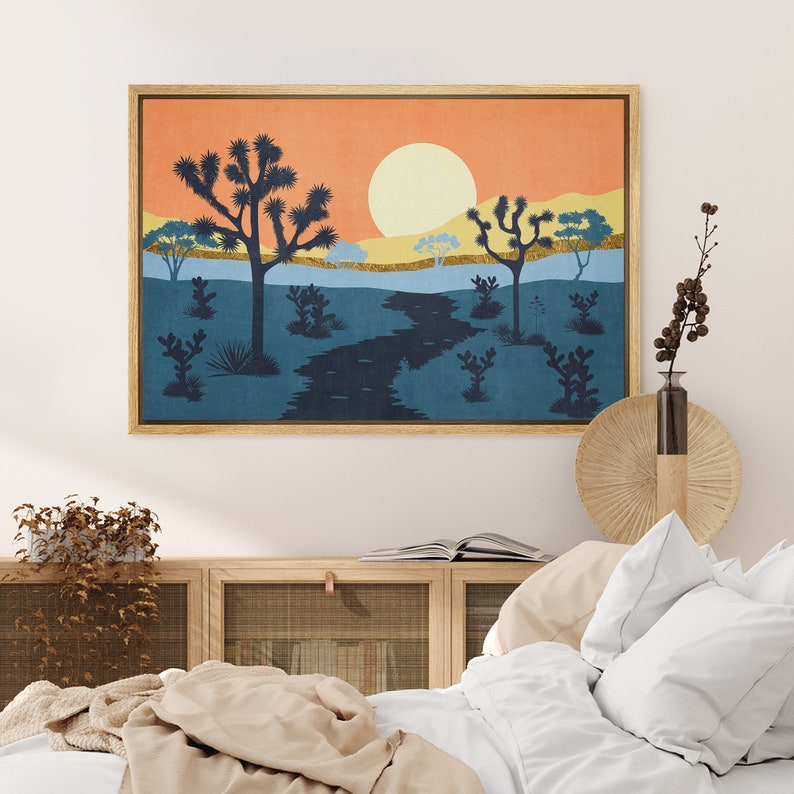 K&ouml;nnte beinhalten: Ein gerahmter Druck einer W&uuml;stenlandschaft mit untergehender Sonne, einem gewundenen Fluss und silhouettenartigen Joshua-B&auml;umen. Der Druck hat ein blaues, oranges und gelbes Farbschema.