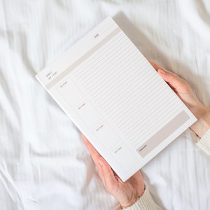 Peut inclure: Un planificateur blanc avec un design rayé gris et blanc. Le planificateur comporte une section pour "Sujet", "Jour / Sujet" et des éléments "À faire". Le planificateur comporte également une section pour "Résumé".