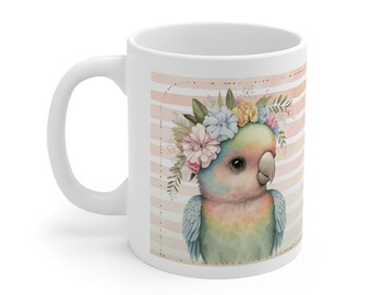 May include: White ceramic mug with a colorful illustration of a parrot wearing a flower crown. The parrot is green, blue, and pink with a yellow beak. The background is pink and white stripes with gold accents.