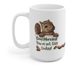 May include: White ceramic mug with a squirrel illustration. The squirrel is peeking over a white surface with the text "Good Morning! You've got this today!" in green. Brown acorns are also featured on the mug. The mug has a large handle.