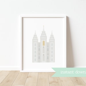 May include: A printable digital download of a minimalist illustration of the Salt Lake Temple in gray and gold colors. The image is framed and displayed on a white wall.