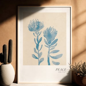 May include: A framed print with a beige background featuring two blue watercolor illustrations of protea flowers. The text "PEACE John 14:27" is printed below the flowers.