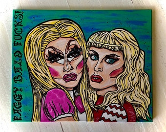 Puede incluir: Un cuadro rectangular sobre lienzo con dos figuras rubias con maquillaje intenso y contornos negros marcados. La figura de la izquierda lleva un guante rosa y la de la derecha un top con patrón de chevrón rojo y blanco. El texto FAGGY BALD FUCKS! está a la izquierda.