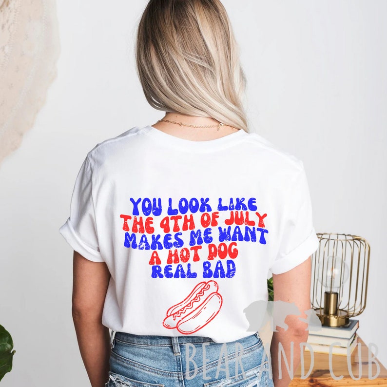May include: White t-shirt with red and blue text that reads "You look like the 4th of July makes me want a hot dog real bad". A red and white hot dog is pictured below the text.