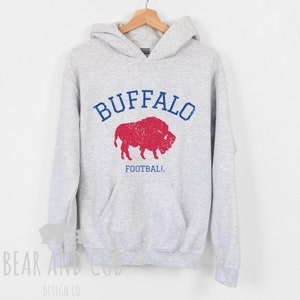 May include: Gray hooded sweatshirt with a distressed red and blue graphic of a buffalo and the text "BUFFALO FOOTBALL".
