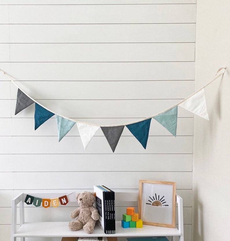 Blue linen bunting decoration for nursery on top of kid's bookcase