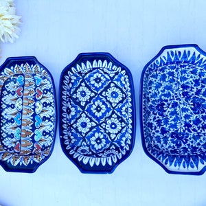 May include: Three blue and white ceramic serving dishes with intricate floral patterns. The dishes are rectangular with rounded corners and have a slightly raised rim.