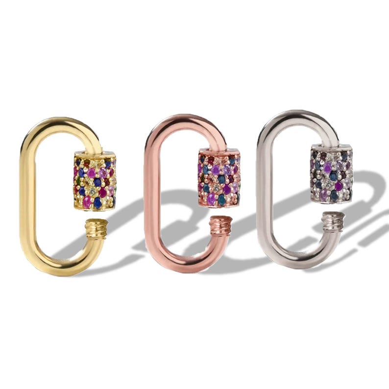 May include: Three oval-shaped jewelry clasps in gold, rose gold, and silver. Each clasp features a cylinder adorned with colourful gemstones. The clasps are designed with a screw-on mechanism for secure closure, ideal for jewelry making.