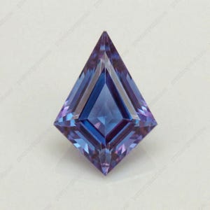 May include: A kite-shaped, faceted gemstone. The colour shifts from deep blue to purple. The facets create a symmetrical pattern, reflecting light. The gemstone is set against a white background. The gem's dimensions are in centimetres.
