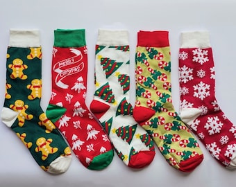 May include: Six pairs of Christmas themed socks. The socks are red, green, and white with various Christmas designs including candy canes, snowflakes, gingerbread men, and Christmas trees. The socks have a white cuff.