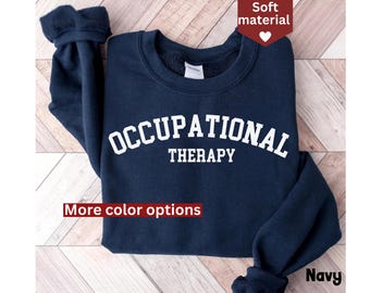 May include: Navy blue sweatshirt with the text "Occupational Therapy" in white. The sweatshirt is folded and displayed on a wooden surface.