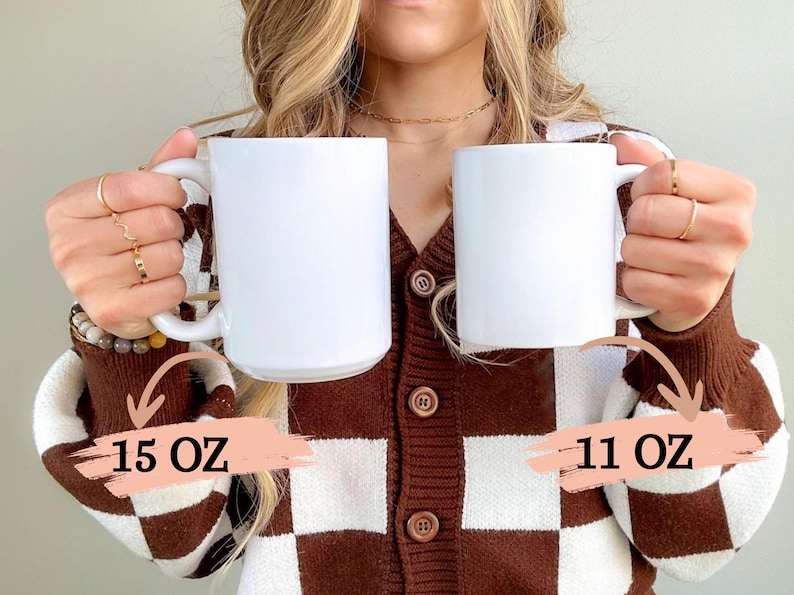 K&ouml;nnte beinhalten: Zwei wei&szlig;e Keramikbecher, einer mit 15 oz und einer mit 11 oz, gehalten von einer Person, die eine braune und wei&szlig;e karierte Strickjacke tr&auml;gt.