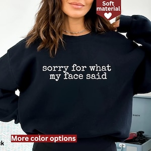 May include: Black sweatshirt with the text "sorry for what my face said" in white. The sweatshirt is a soft material and has more color options available.