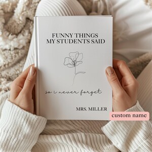May include: A white book titled "FUNNY THINGS MY STUDENTS SAID" with a floral line drawing. The text "so I never forget" and "MRS. MILLER" are below the title. The book is held by a person wearing a white sweater.