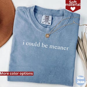 May include: A blue t-shirt with the text "i could be meaner" printed in white. The shirt is made of a soft material and has a distressed look.