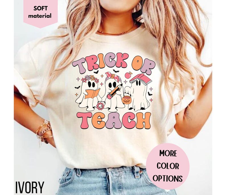 May include: Ivory-colored t-shirt with the words "Trick or Teach" in a retro font. The design features three ghost characters holding a book, pencil, and pumpkin bucket. The shirt is labeled "soft material" and "more color options".