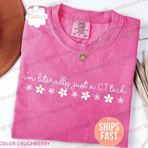 May include: A pink short-sleeved t-shirt with a crew neckline and a Comfort Colors brand label. The shirt features the white text "i'm literally just a CT tech" above a row of white daisy graphics with yellow centers, printed on the front chest.
