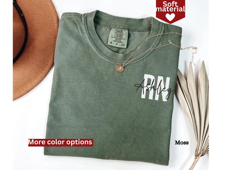 May include: A green t-shirt with the text "RN Ashley" printed on the front. The shirt is made of a soft material and is available in a variety of colors.