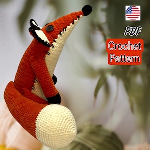 May include: A crochet pattern for a fox amigurumi toy. The pattern is available as a PDF download. The fox is orange and white with black accents.