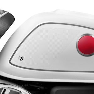 Puede incluir: Depósito de gasolina de motocicleta blanco con un botón rojo y un logotipo negro en el lateral.