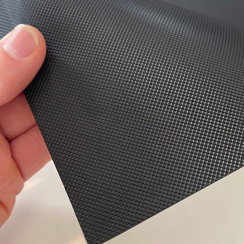May include: Black textured rubber sheet with a diamond pattern.
