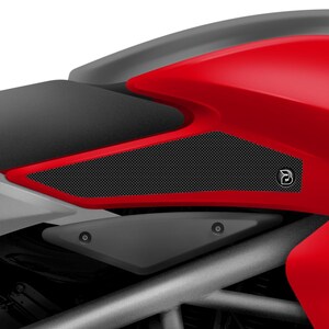 Puede incluir: Una motocicleta roja con protectores de tanque negros con un patrón de panal. Los protectores están diseñados para proteger el tanque de la motocicleta de arañazos y rozaduras.