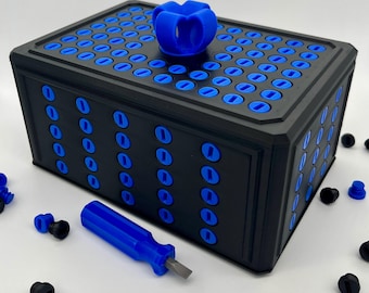 Puede incluir: Una caja de almacenamiento rectangular negra con una rejilla de inserciones circulares azules en la parte superior y los lados, rematada con un asa azul de cuatro pétalos. Un pequeño destornillador azul con punta plana metálica se sitúa frente a la caja, rodeado de componentes circulares negros y azules.