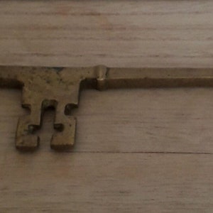 Peut inclure: Une clé en laiton avec une tête décorative et ornée et un ouvre-bouteille à l'autre extrémité.