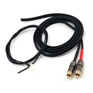 Op de afbeelding: Een zwarte audiokabel met twee RCA-connectoren met vergulde uiteinden, waarvan er één is gemarkeerd met een rode huls. De kabel bevat een geïntegreerde dunne zwarte aardingsdraad die eindigt in een goudkleurige U-vormige kabelschoen.