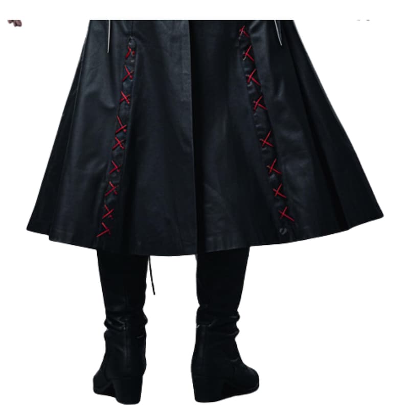 May include: Black faux leather coat with red cross-stitch detailing on the sides. The coat has a flared skirt and is paired with black leggings and wedge boots. The overall style is gothic and edgy.