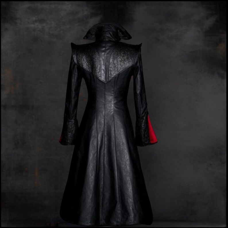 Pu&ograve; includere: Un lungo cappotto di pelle nera con un colletto alto e dettagli rossi sui polsini. Il cappotto ha un corpetto aderente e una gonna fluida.